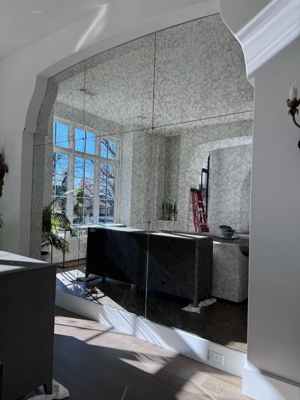 Antiqued mirror wall with decorative arch — upscale dining room