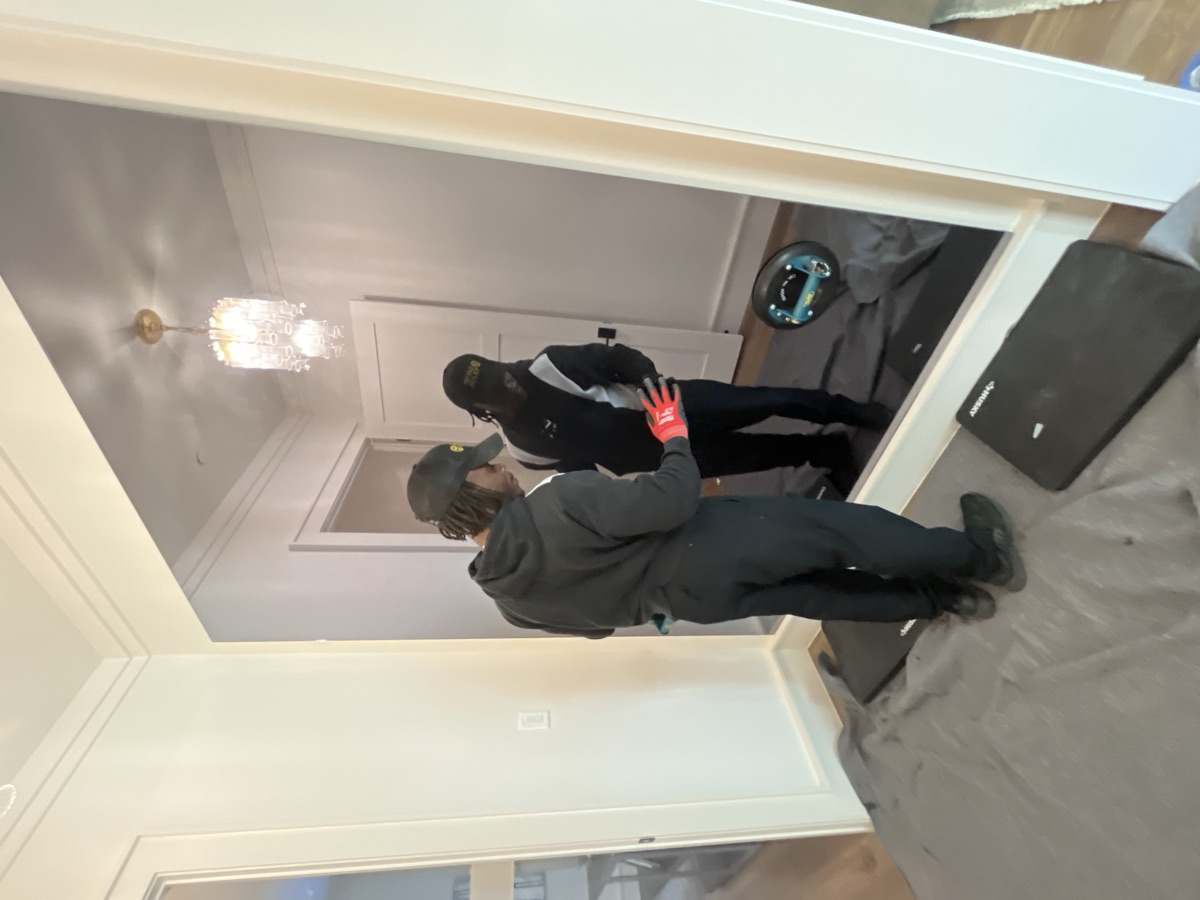Large mirror installation in progress — two-man team