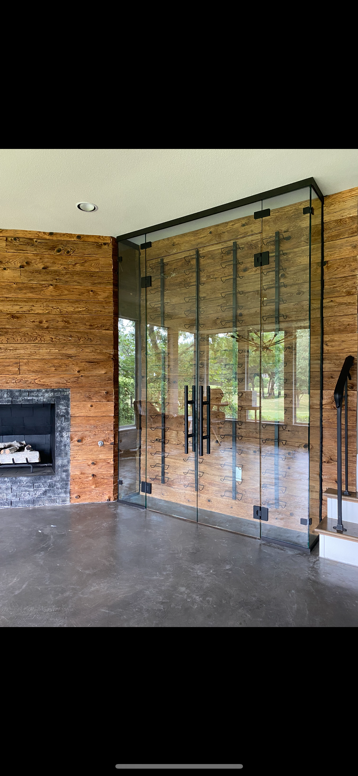 Custom glass wine cellar doors with rustic wood and stone surround