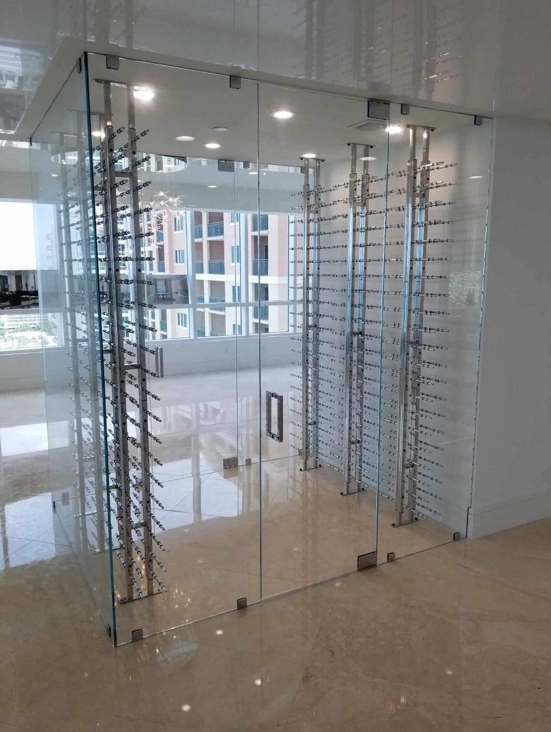 Frameless glass wine enclosure with chrome peg racks — high-rise condo